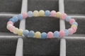 Detail of multi-color morganite beaded bracelet set on a grey jewelry display case - 6mm