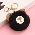 Detailed view of black plush faux fur keychain with brown ears and golden metal clasp - Black