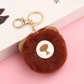 Detail of cute brown faux rabbit fur keychain with embroidered tree on leather patch - Caramel color