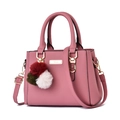 Elegante bolso de piel rosa palo con herrajes dorados y un colgante de pompón colorido - Rosa