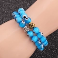 Double-layer beaded Evil Eye bracelet with gold Buddha head charm on a model's wrist - Lake Blue Set