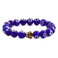 Detailed shot of blue evil eye beads with a golden buddha head on the bracelet - Blue Eye Gold Buddha Head