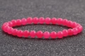 Detalle macro de cuentas de piedra natural rosa de 6mm en una pulsera elástica brillante - Rosa suave (14)