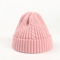 Close-up of pink cable knit beanie showing thick ribbed cuff and textured wool pattern - Pink