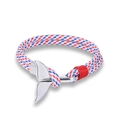 Macro detail of nautical rope bracelet with silver whale tail charm in red white blue colors - White