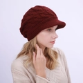 Detailansicht der burgunderroten Strickmütze mit Zopfmuster und Schirm für Damen im Herbst - Einheitsgröße / Dunkelrot