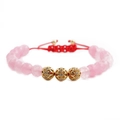 Macro detail of faceted pink beads and gold hollow pavé charms on adjustable red cord - Pink