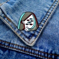 Detail of surreal enamel brooch with multiple eyes pinned on a blue denim jacket - Multi-eye Face