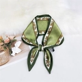 Elegant green silk scarf with chain pattern and planet logo tied in a bow on fur - Green Orb Chain Pattern