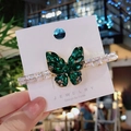 Butterfly hair clip with green zircon crystals and gold finish on a jewelry card - Green