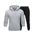 Zweiteiliges Sportset bestehend aus grauem Kapuzenpullover und schwarzer Jogginghose - Grau/Schwarz