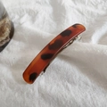 Detailed view of amber tortoiseshell hair clip with premium matte resin and metal spring - Dark Leopard