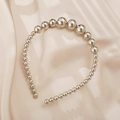 Elegant metallic beaded headband with gradient size beads on champagne silk background - Silver Metal Bead Style