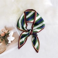 Silky green and royal blue geometric scarf tied in a bow on a white faux fur background - Layered Striped Green