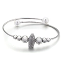 Silver-toned cable bangle with white pearls and Virgin Mary medal pendant on white base - Silver