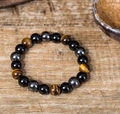 Tiger eye and hematite beaded bracelet on a vintage wooden background for a Zen style - Tiger Eye & Hematite