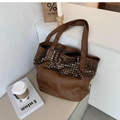 Detailed view of large brown tote bag with silver studs on clean white background - Brown