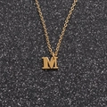 Golden stainless steel letter M pendant necklace displayed on a black glitter background - Gold M