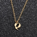 Detailed view of a golden letter Q pendant on an O-chain necklace against a black background - Gold Q
