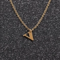 Close-up of a gold V-shaped letter pendant on a delicate chain against a dark background - Gold V