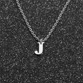 Macro view of a silver letter J pendant necklace with a fine stainless steel chain - Steel J