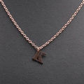 Close-up of a polished rose gold letter K pendant necklace on black leather surface - Rose Gold K