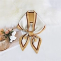 Elegant gold and brown heart pattern silk ribbon scarf tied in a bow on soft fur - Single Heart Yellow