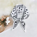 Beige twilly scarf with black skull pattern on soft white plush background - Skull White