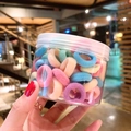 Colorful macaron hair ties for girls in a portable clear jar held by hand - 100 Pcs Jar / Spring Colors
