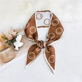 Brown skinny silk scarf with white smiley pattern tied in a bow on a white fur mat - Smiley Brown