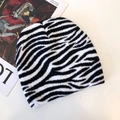Close-up of black and white knit beanie with zebra pattern on fashion magazine - Zebra Stripe