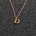 Primer plano de un collar de acero inoxidable dorado con un colgante de la letra D - Oro D