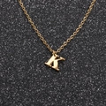 Macro shot of gold letter K pendant with fine chain on a shimmering black background - Gold K