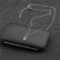 Macro detail of stainless steel G-letter pendant necklace on a black textured box - Steel G