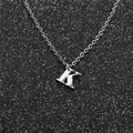 Macro shot of a silver letter K pendant on a fine metal chain over black textured background - Steel K