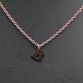 Detail of rose gold alphabet B pendant necklace on textured black leather background - Rose Gold B