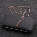 Macro detail of rose gold letter E pendant on an O-chain over a black textured surface - Rose Gold E
