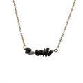 Collier doré avec pierres irrégulières noires et grises posé à plat sur un fond blanc pur - Pierre concassée noire et grise (1)