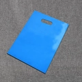 Bright blue PE plastic retail gift bag with punch handle on grey textured background - Blue