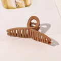 Macro detail of a large caramel brown matte hair claw clip on a minimalist card background - 11cm Cross - Matte Orange