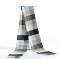 Detailed shot of classic black and white plaid scarf with soft fringe tassels on a display - Light Grey Black White Grid