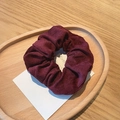 Close-up of a burgundy corduroy scrunchie texture on a decorative wooden tray - Burgundy