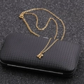 Macro detail of gold stainless steel necklace with letter R pendant on a black box - Gold R