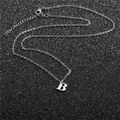 Macro view of minimalist silver stainless steel necklace with letter B pendant detail - Steel B