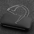 Close-up of silver-tone stainless steel alphabet necklace on carbon fiber display box - Steel O