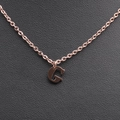 Close-up of rose gold stainless steel G-letter pendant necklace on black leather - Rose Gold G