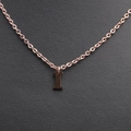Macro shot of a rose gold letter I pendant necklace on a premium black leather background - Rose Gold I