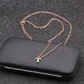 Detailed view of rose gold letter T necklace pendant on black textured jewelry box - Rose Gold T