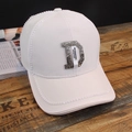 White baseball cap featuring rhinestone letter D and decorative ribbon on wooden desk - D Label White