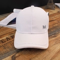 White baseball cap with pearl trim and silver metal M logo on vintage wood background - M Label White
